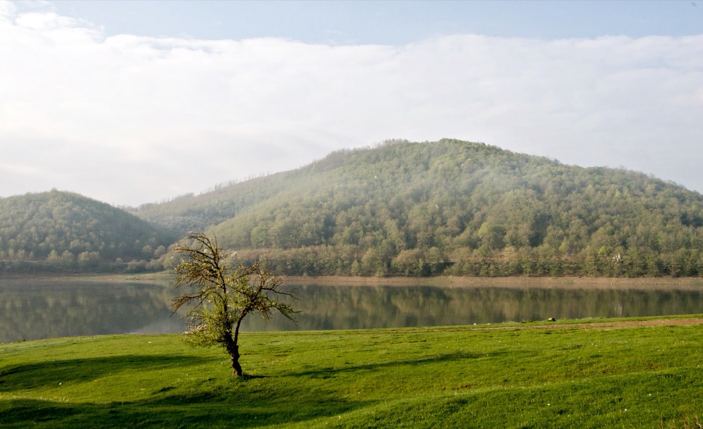 The far shore, out of season. In August this side fills with tents, kayaks and a stage.
